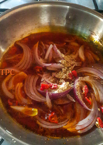 onions and chopped pepper frying in palm oil for fiofio pigeon peas