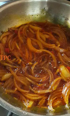 onion slices frying in palm oil for fiofio pigeon peas