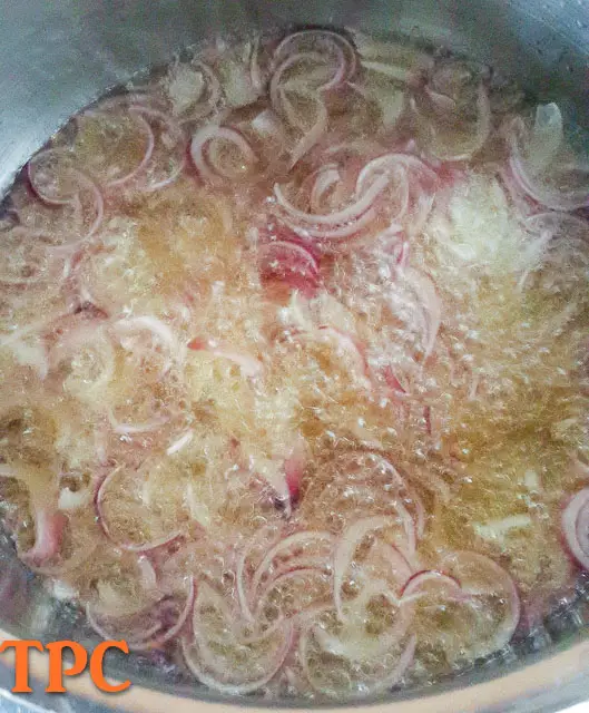 onions frying in vegetable oil for nigerian tomato stew base