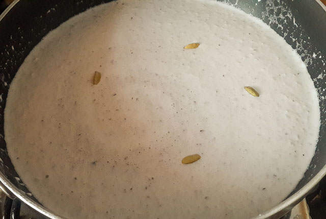 shredded coconut, coconut milk, cardamom in sauce pan for Indian coconut ladoo