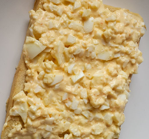 mashed egg and mayonnaise on slice of bread for boiled egg sandwich