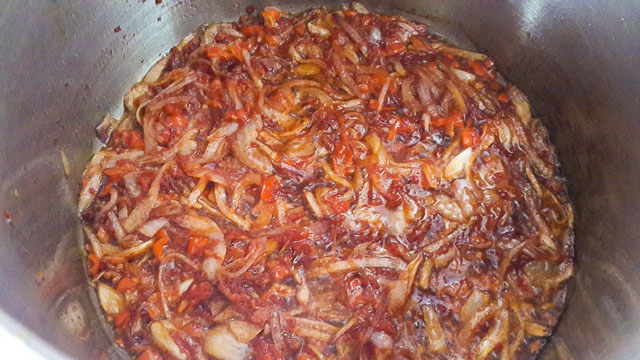 onions and pepper frying for Nigerian palm oil jollof rice