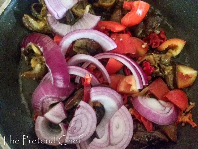 snails and vegetables frying for Nigerian peppered snail