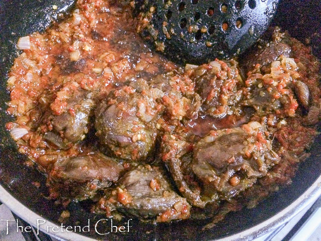 nigerian peppered gizzard frying in frying pan with peppers 