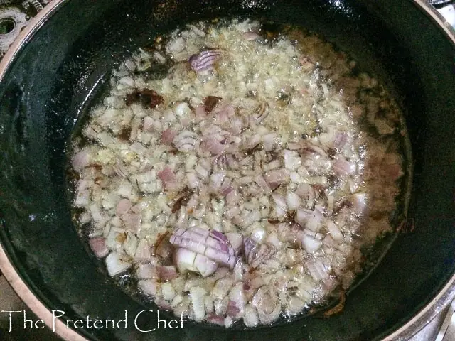 chopped onions frying in a frying pan fornigerian peppered gizzard 
