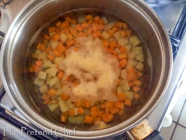 cubed carrots and potatoes boiling in a pot for Nigerian vegetable salad