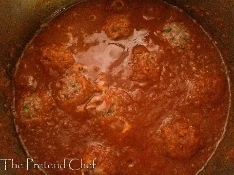 spaghetti and meatballs in tomato sauce in a pot