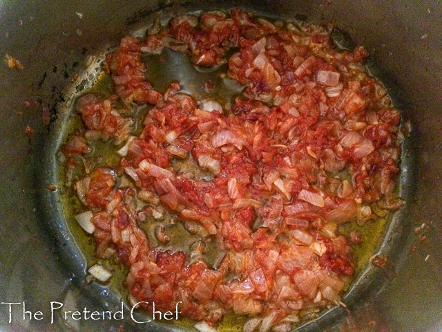 tomato puree added to frying onions in a pot for fresh tomato sauce