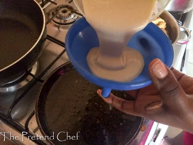 funnel cake batter being poured into funnel
