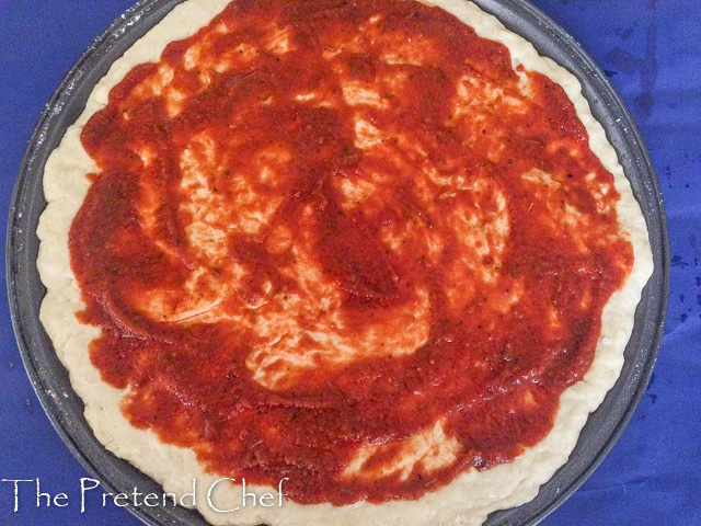 homemade pizza sauce on pizza dough