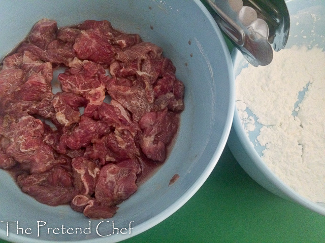 shredded beef being drenched in flour for mongolian beef stir fry