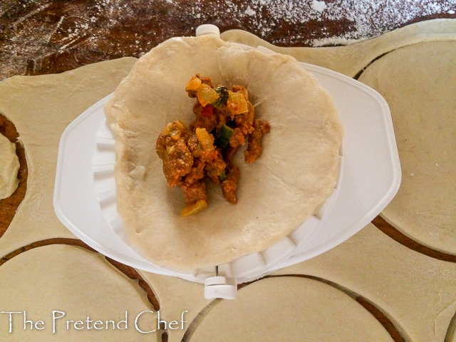 disc of Empanada dough being filled