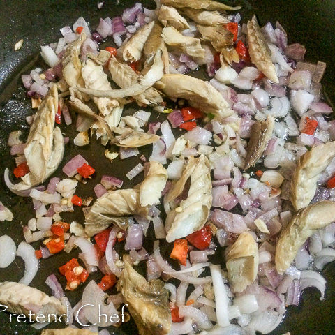 smoked fish with greens frying in a saucepan