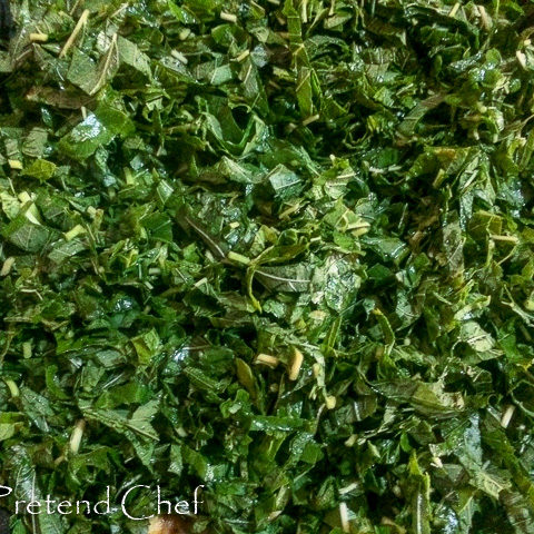 smoked fish with greens frying in a saucepan