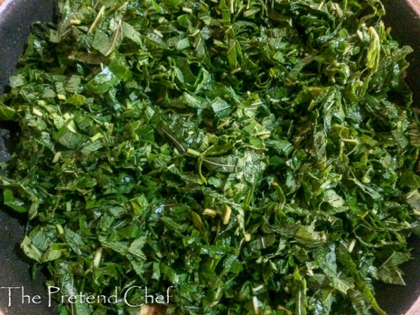 smoked fish with greens frying in a saucepan