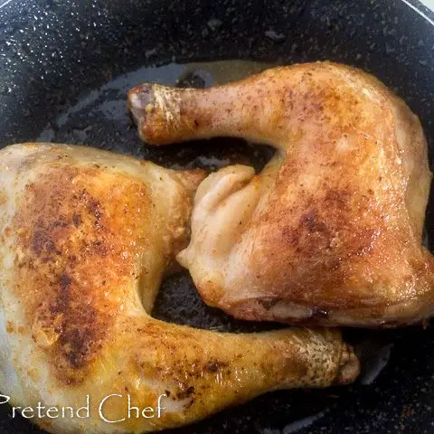 chicken legs frying in pan