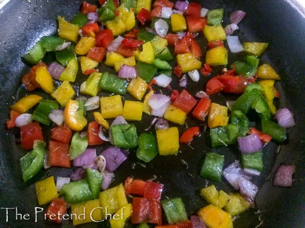 peppers and onions frying in a pan for Couscous with bell peppers