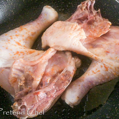 chicken legs frying in pan