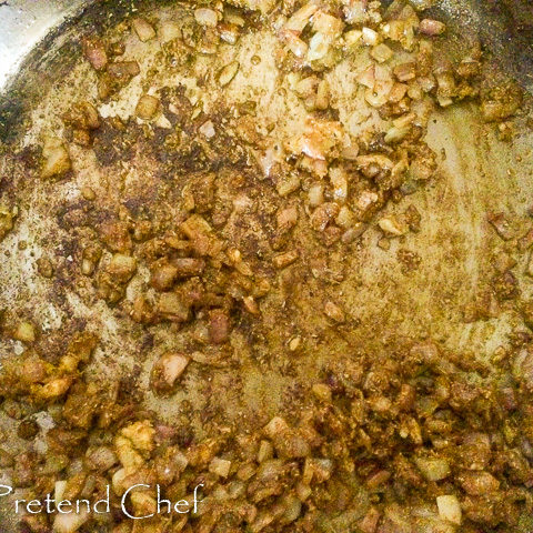 curry powder added to onions frying in a saucepan