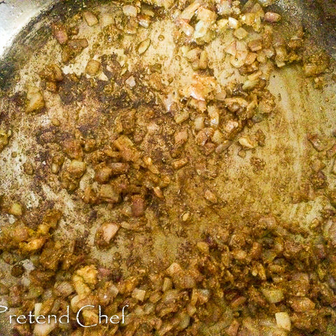 curry powder added to onions frying in a saucepan