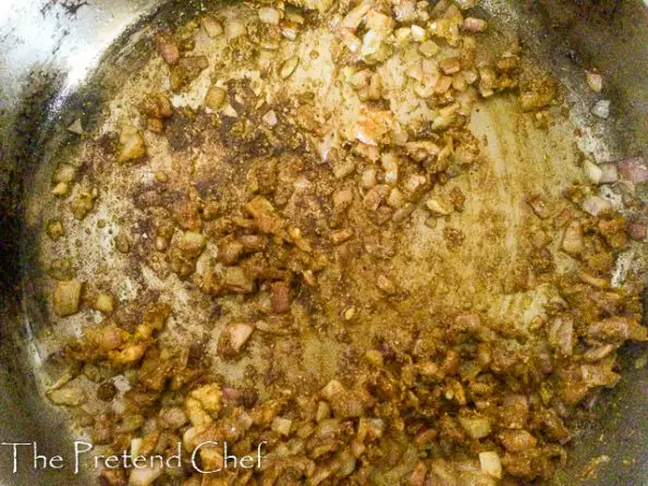curry powder added to onions frying in a saucepan
