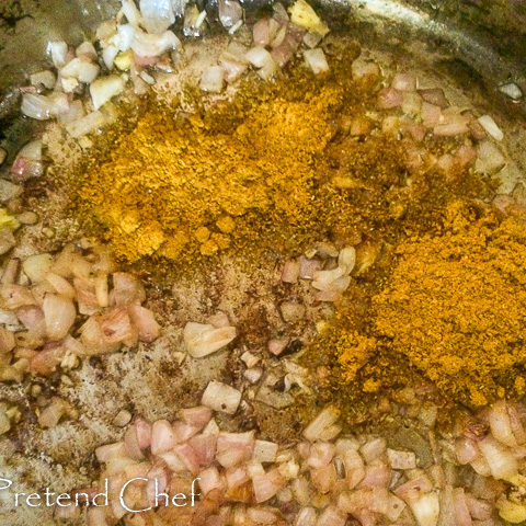 curry powder added to beef frying in a saucepan