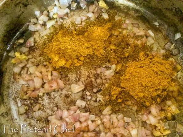 curry powder added to beef frying in a saucepan
