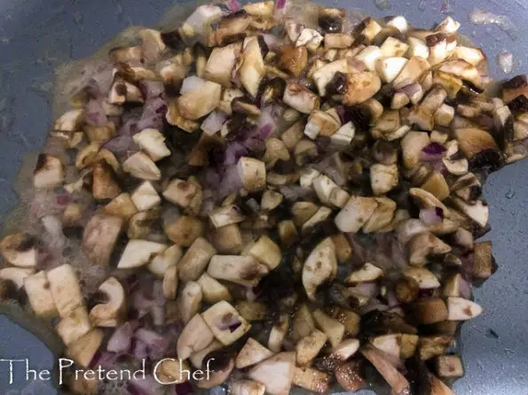 chopped mushrooms frying in a frying pan