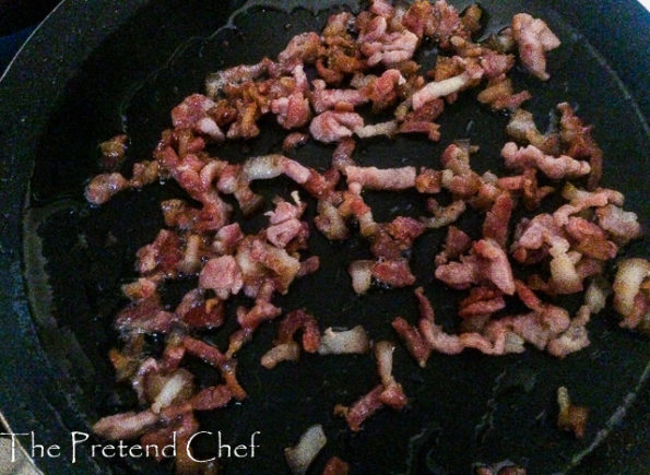 chopped bacon frying in a frying pan