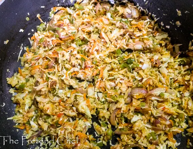 Shredded vegetables in a frying pan for cabbage rice
