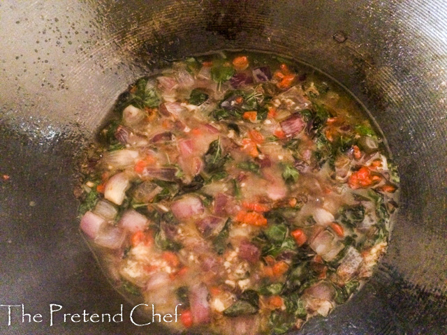 fish curry leaf rice cooking in a saucepan