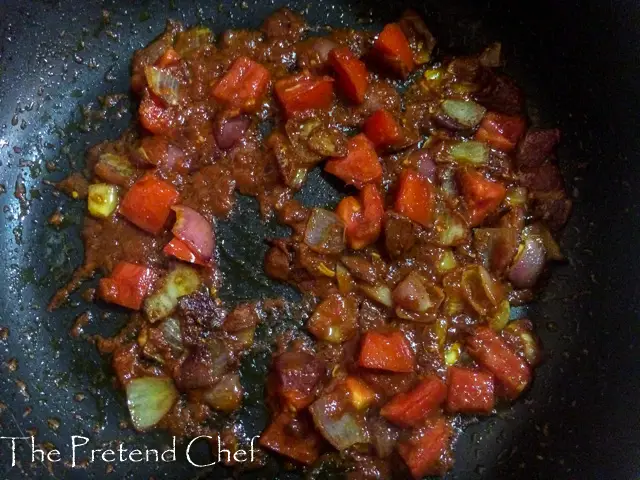 vegetables sauteing in a frying pan for Nigerian Tomato Rice recipe using leftover rice