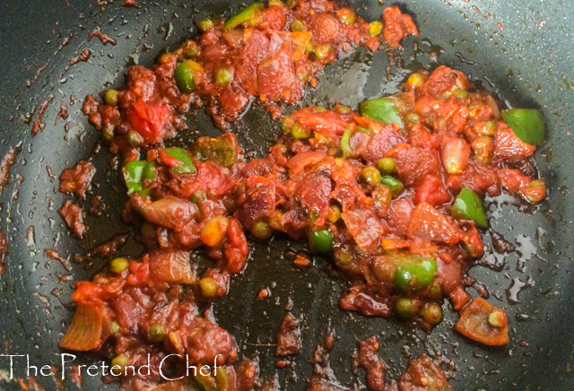 Vegetables sauteing in a frying pan for Nigerian Tomato Rice recipe using leftover rice