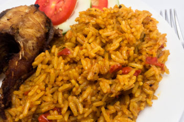 Nigerian coconut jollof rice in a plate with fish and vegetables