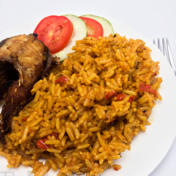 Nigerian coconut jollof rice in a plate with fish and vegetables