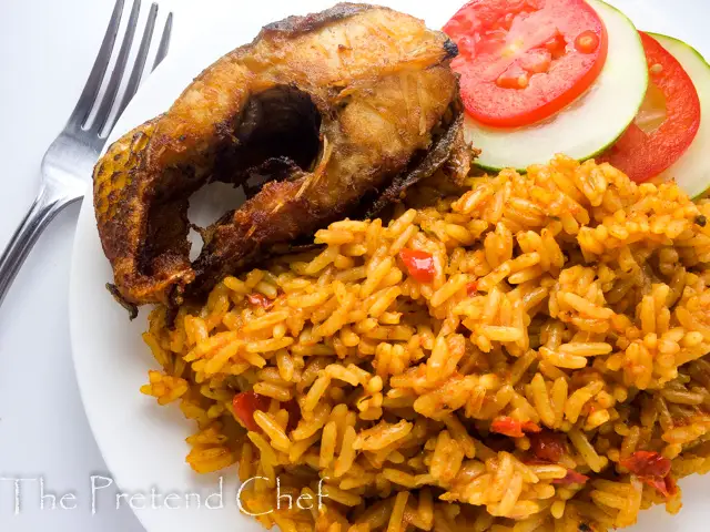 Nigerian coconut jollof rice in a plate with fish and vegetables