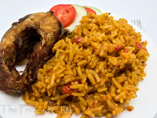 Nigerian coconut jollof rice in a plate with fish and vegetables