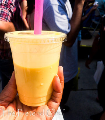 hand holdiing cup of mango lassi