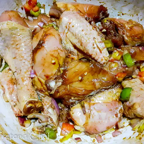 chicken parts marinate in a bowl