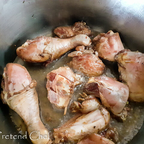 chicken parts frying in a pot