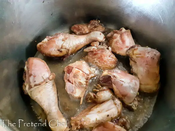 chicken parts frying in a pot