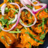 Delicious Nkwobi (cowleg) in a plate with red onions and utazi