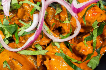 Delicious Nkwobi (cowleg) in a plate with red onions and utazi