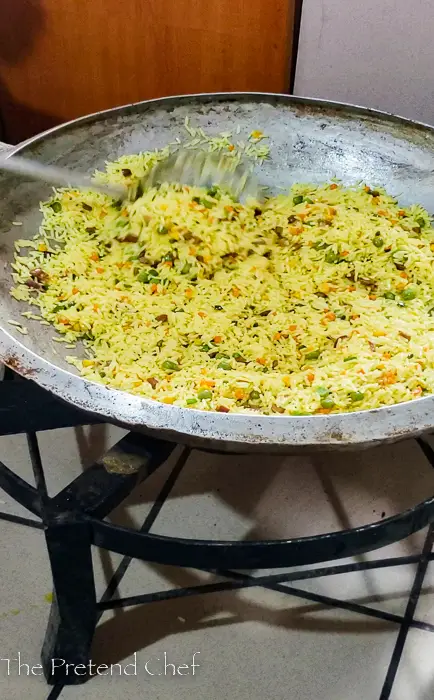 Nigerian Fried Rice for 100 people in a large frying pan