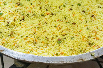 Nigerian Fried Rice for 100 people in a large frying pan