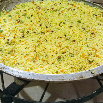 Nigerian Fried Rice for 100 people in a large frying pan