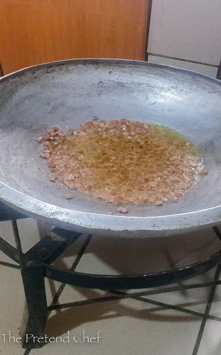 Chopped hotdogs and onions frying