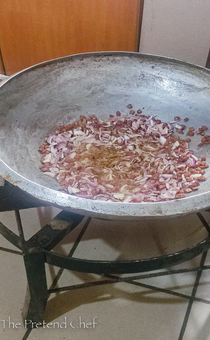 Chopped hotdogs and onions frying